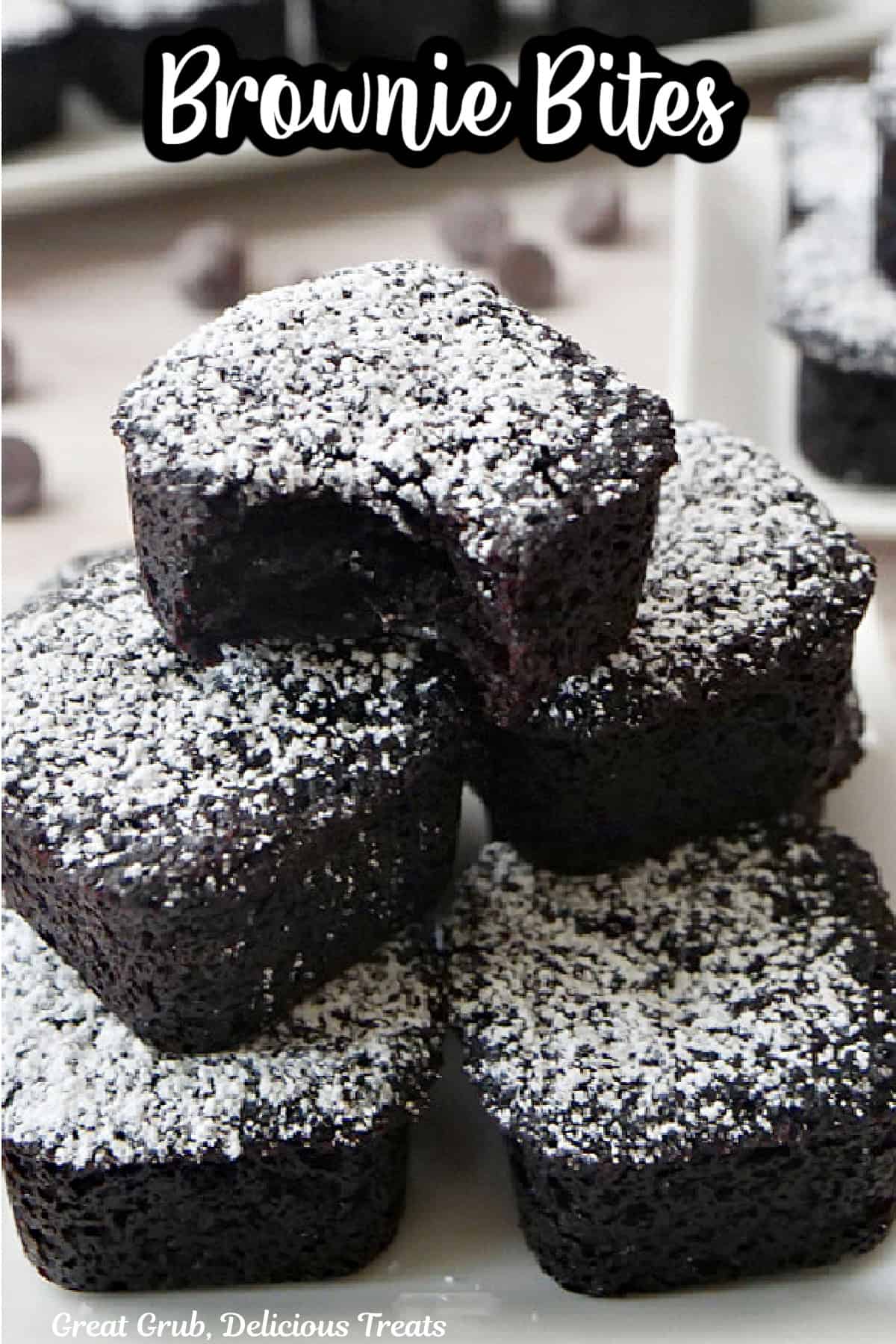 Mini brownie bites with powdered sugar on top of each one.
