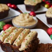 Mini gingerbread cakes with frosting on white plates.