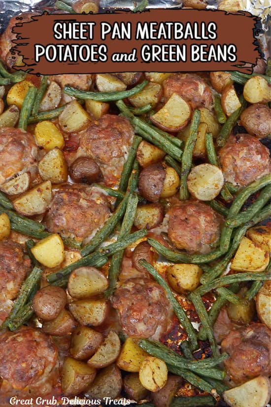 A sheet pan filled with meatballs and potatoes with green beans after being removed from the oven.