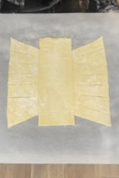 Showing how a puff pastry dough is cut for making a pastry braid.