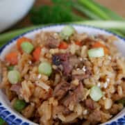 A white bowl with blue trim with a serving of the fried rice in it.