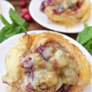 Two round plates with a cinnamon roll on each.