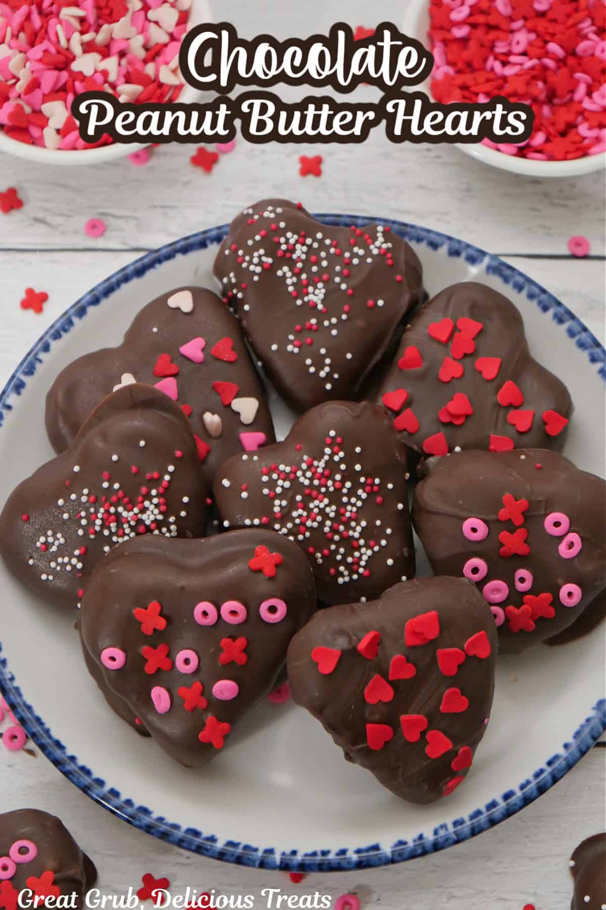 A white surface with a white plate with blue trim with peanut butter hearts covered in chocolate on it with the title overlay at the top.