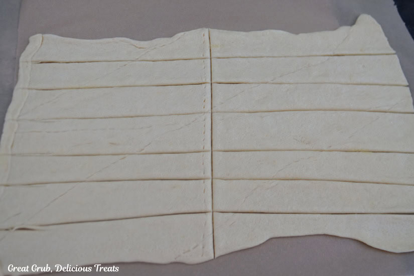 A crescent dough rolled smooth and cut in 7 long strips then cut in half.