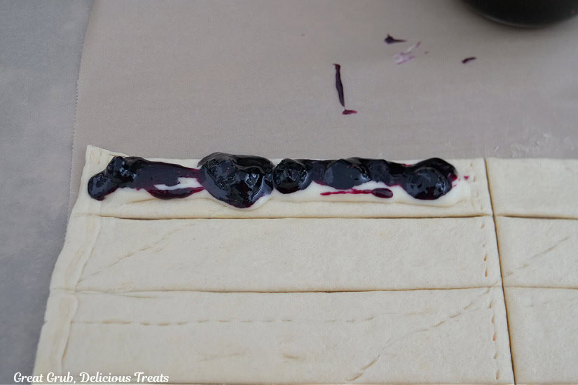 Cream cheese mixture and a blueberry filling added to one of the strips of crescent.