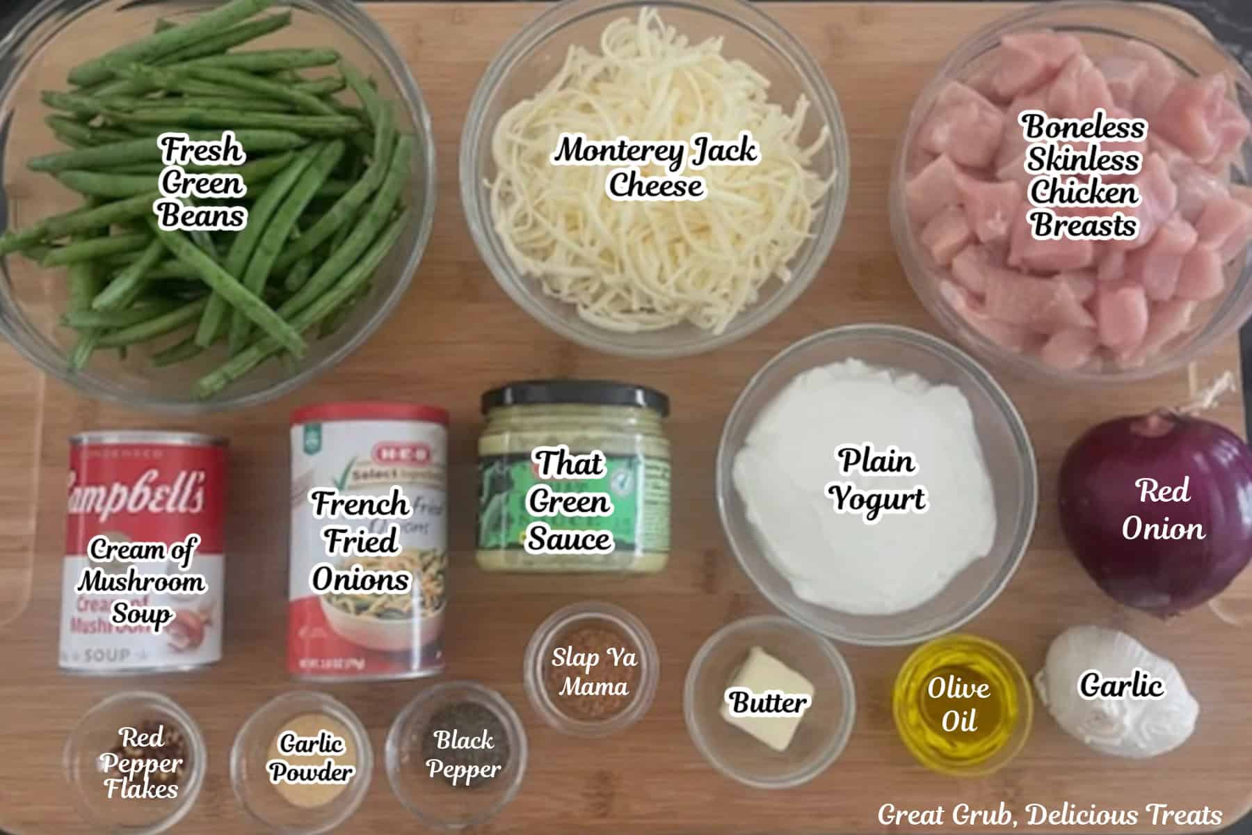 A wood surface with all the ingredients on it to make cheesy chicken green bean casserole.