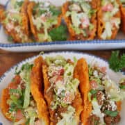 A round white plate with blue trim with three cheesy Doritos mini tacos on it with a title overlay at the top.