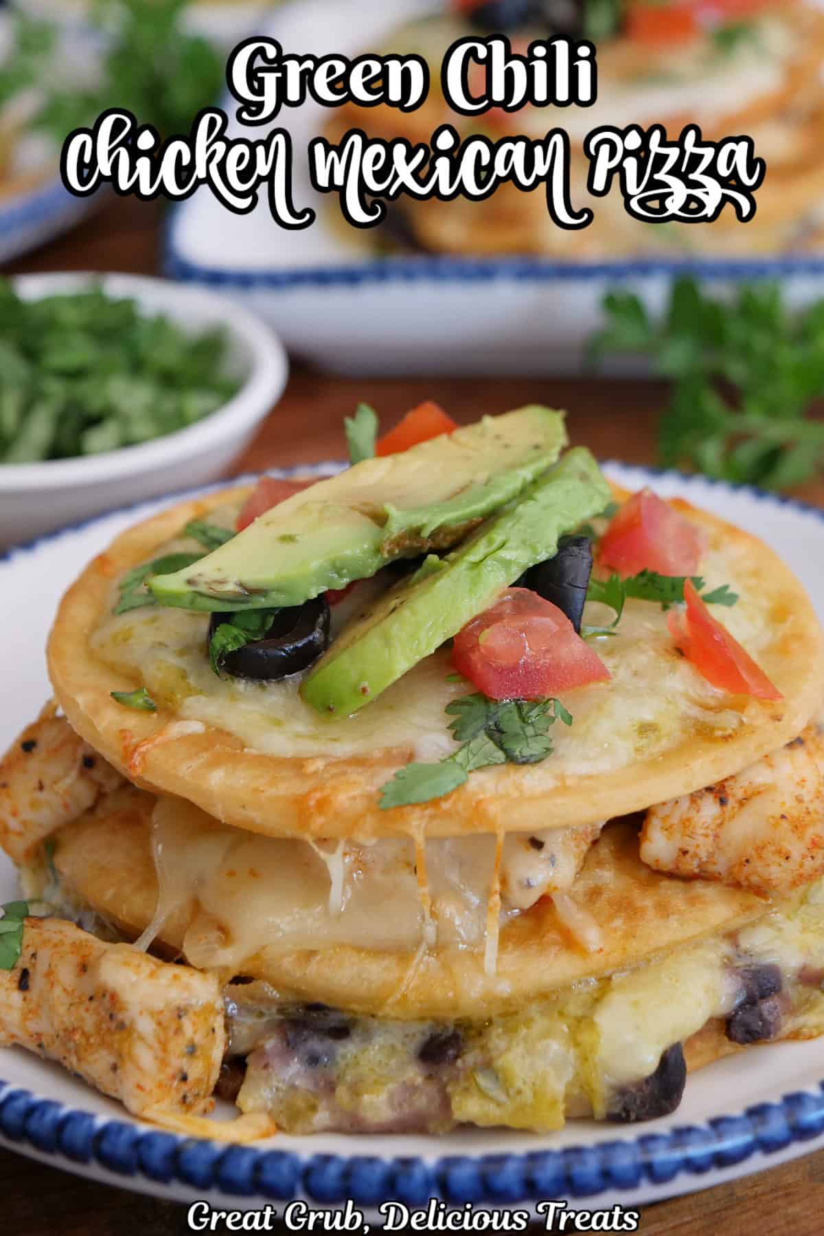 A round white plate with blue trim with a mini three layered Mexican pizza with chicken black beans, cheese, green sauce, and more.