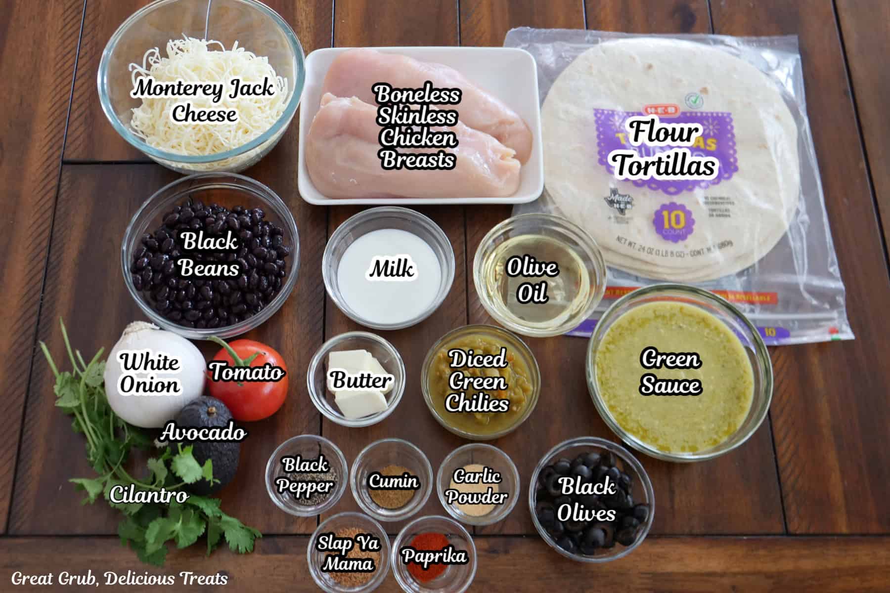 A brown wood surface with all the ingredients place on it to make mini green chili chicken Mexican pizzas.