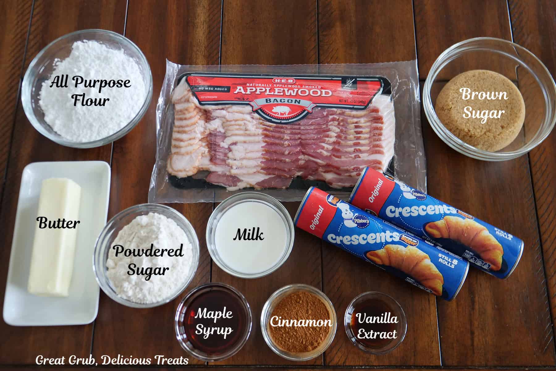 A brown wood surface with all the ingredients to make maple bacon muffins placed on it.