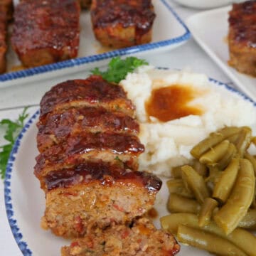 A white plate with blue trim with a mini sliced turkey meatloaf, mashed potatoes, and green beans on it, and a title overlay at the top.