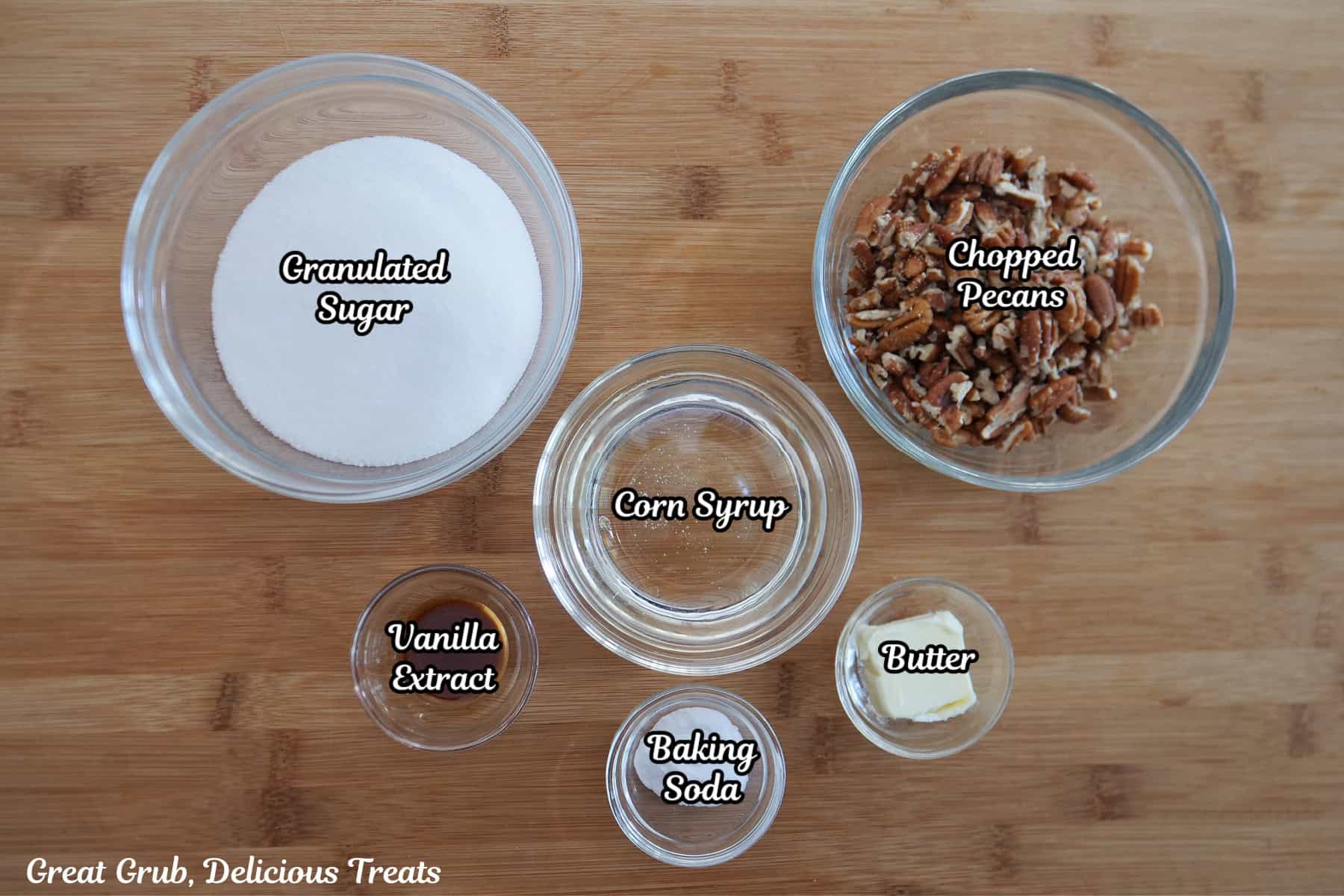 A wood surface with the six ingredients needed to make pecan brittle on it.
