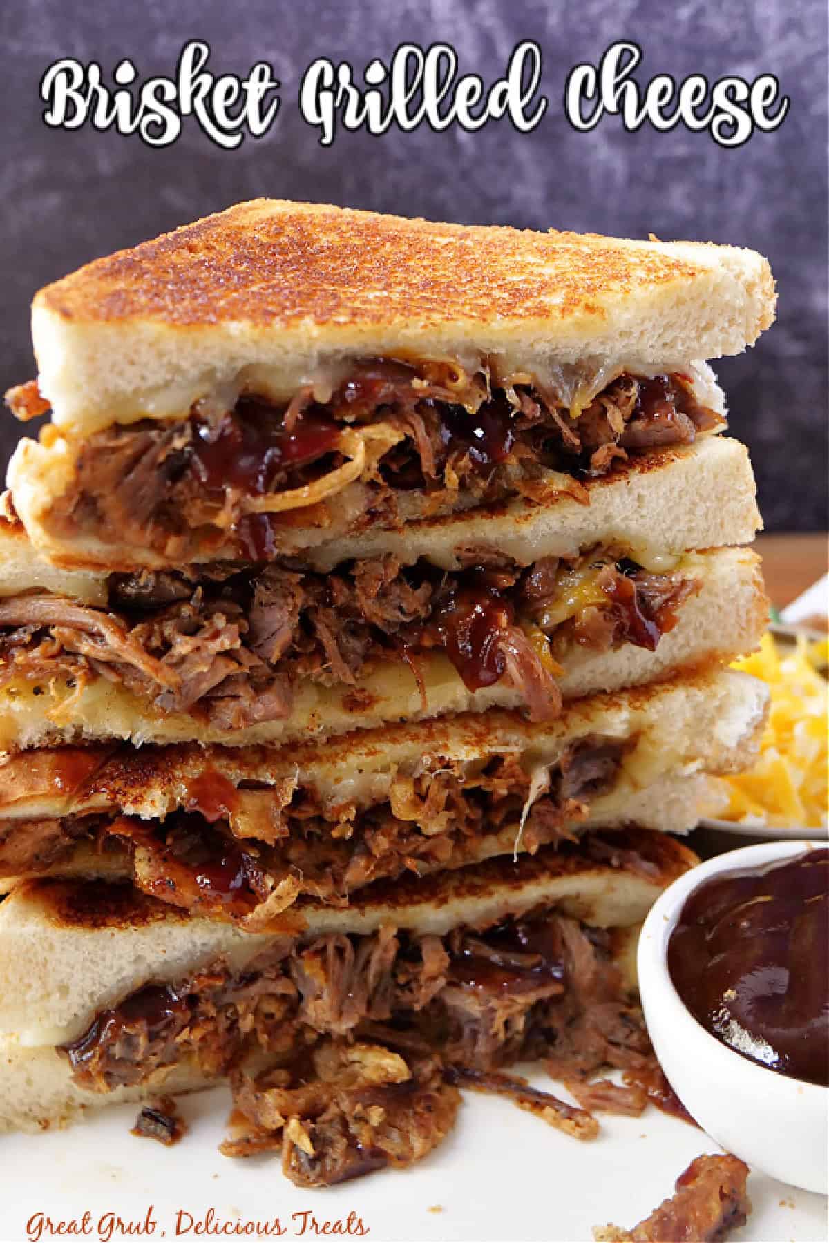 A stack of four halves of brisket grilled cheese sandwiches on top of each other showing all the brisket and cheese inside, and a title overlay at the top.
