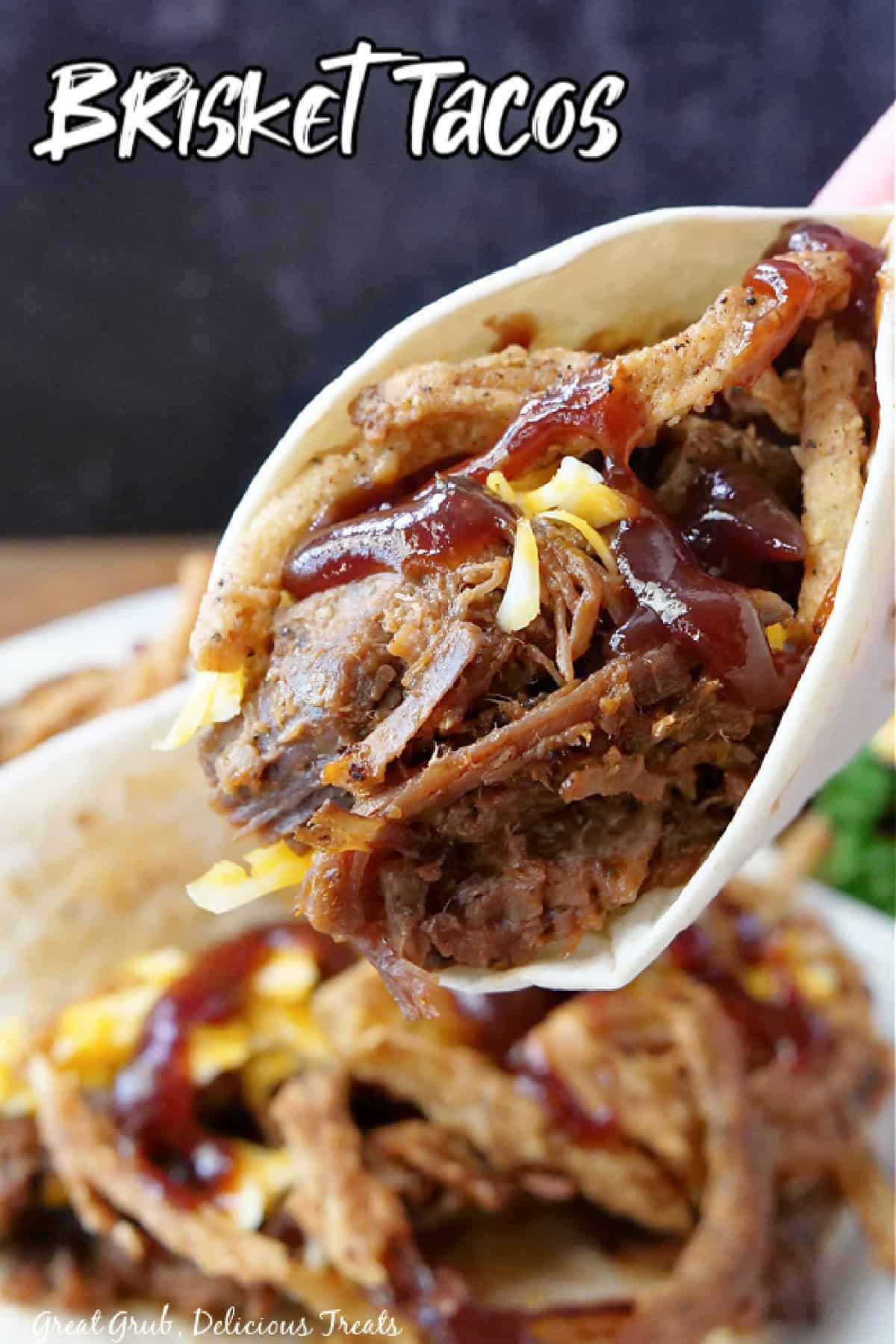 A brisket taco held up, above a plate of brisket tacos, showing all the stuffed brisket and cheese in it, and a title overlay at the top.