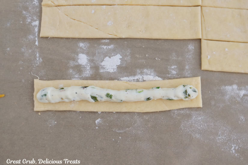 A strip of crescent dough with a strip of cream cheese mixture on top.