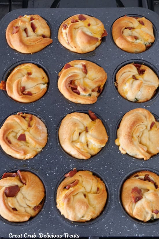 A 12-count muffin tin with baked jalapeno popper muffins in it after being baked.