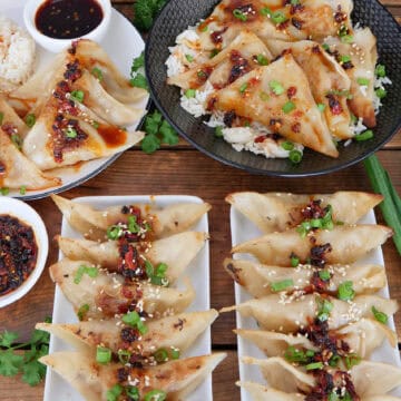A wood surface with chili crisp pork potstickers on white plates with a title overlay at the top.