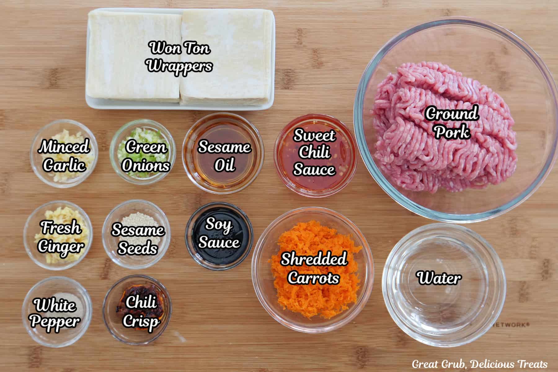 A wood cutting board with all the ingredients on it to make chili crisp pork potstickers.