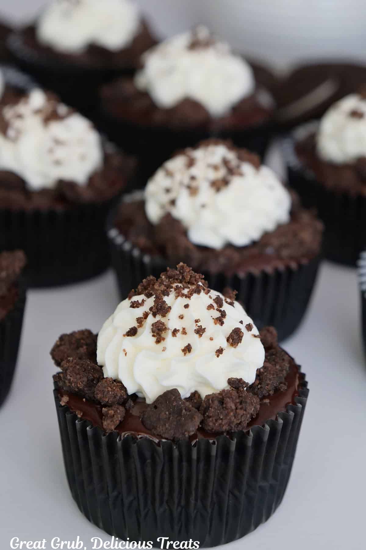 A white surface with mini chocolate crunch cheesecake on it.