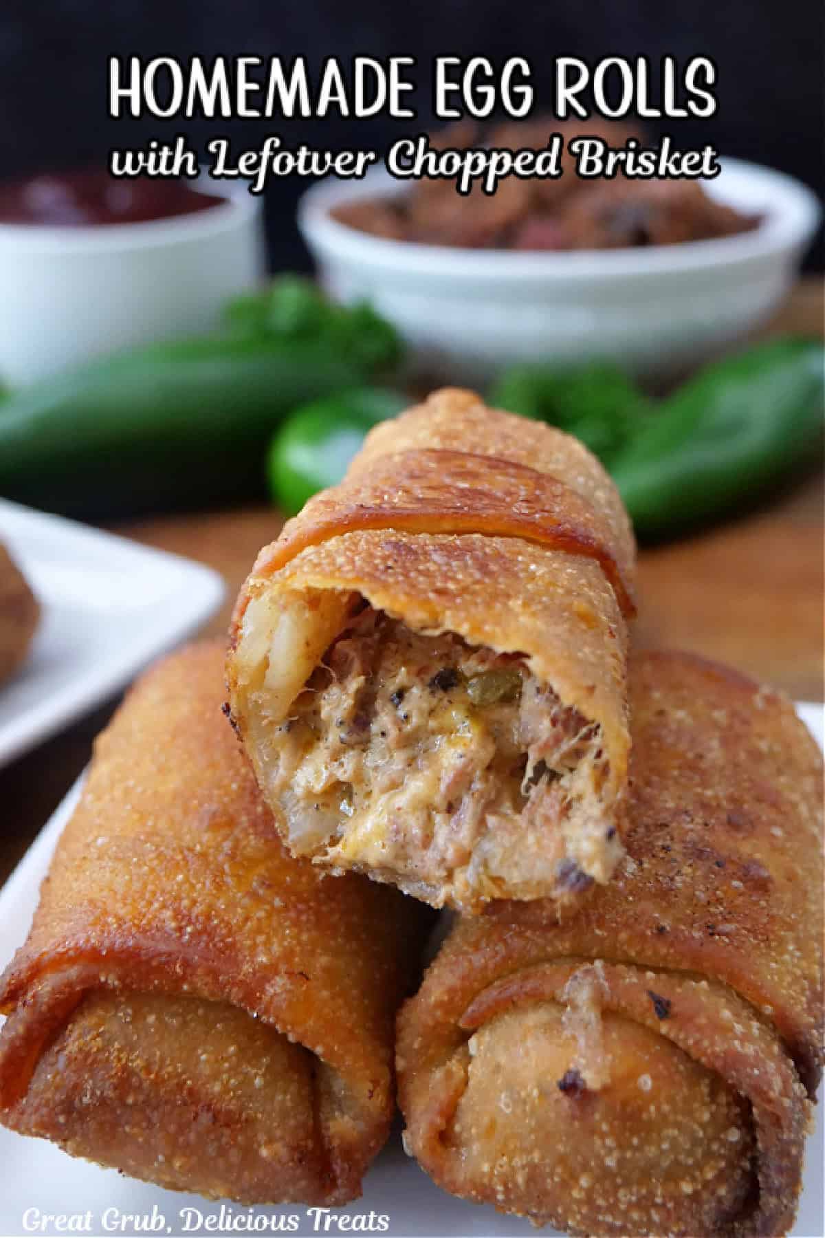 Three fried homemade egg rolls stuffed with leftover chopped brisket, cheese and more with a bite taken off the egg roll on top, and a title overlay at the top.
