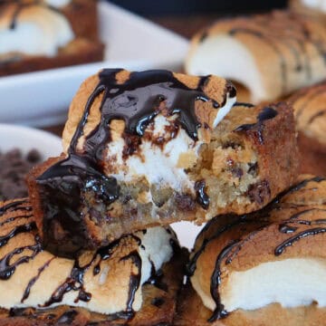 A white plate with three S'mores blondies on it with a bite taken out of the one on top, and a title overlay at the top.