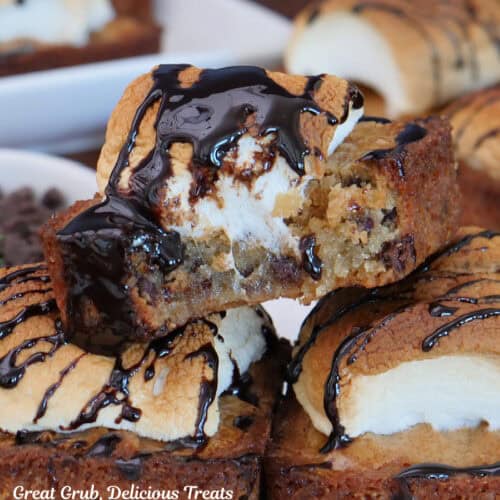 A close up photo of S'more blondies on a white plate with a bite taken out of the blondie on top.