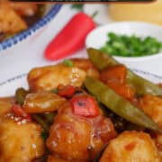 A round white plate with blue trim filled with a serving of spicy chicken stir-fry with a title overlay at the top.