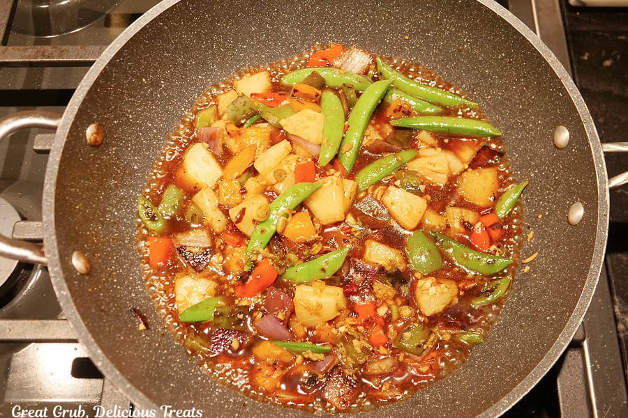 A frying pan with all the vegetables and the sauce in it and bringing it to a boil.