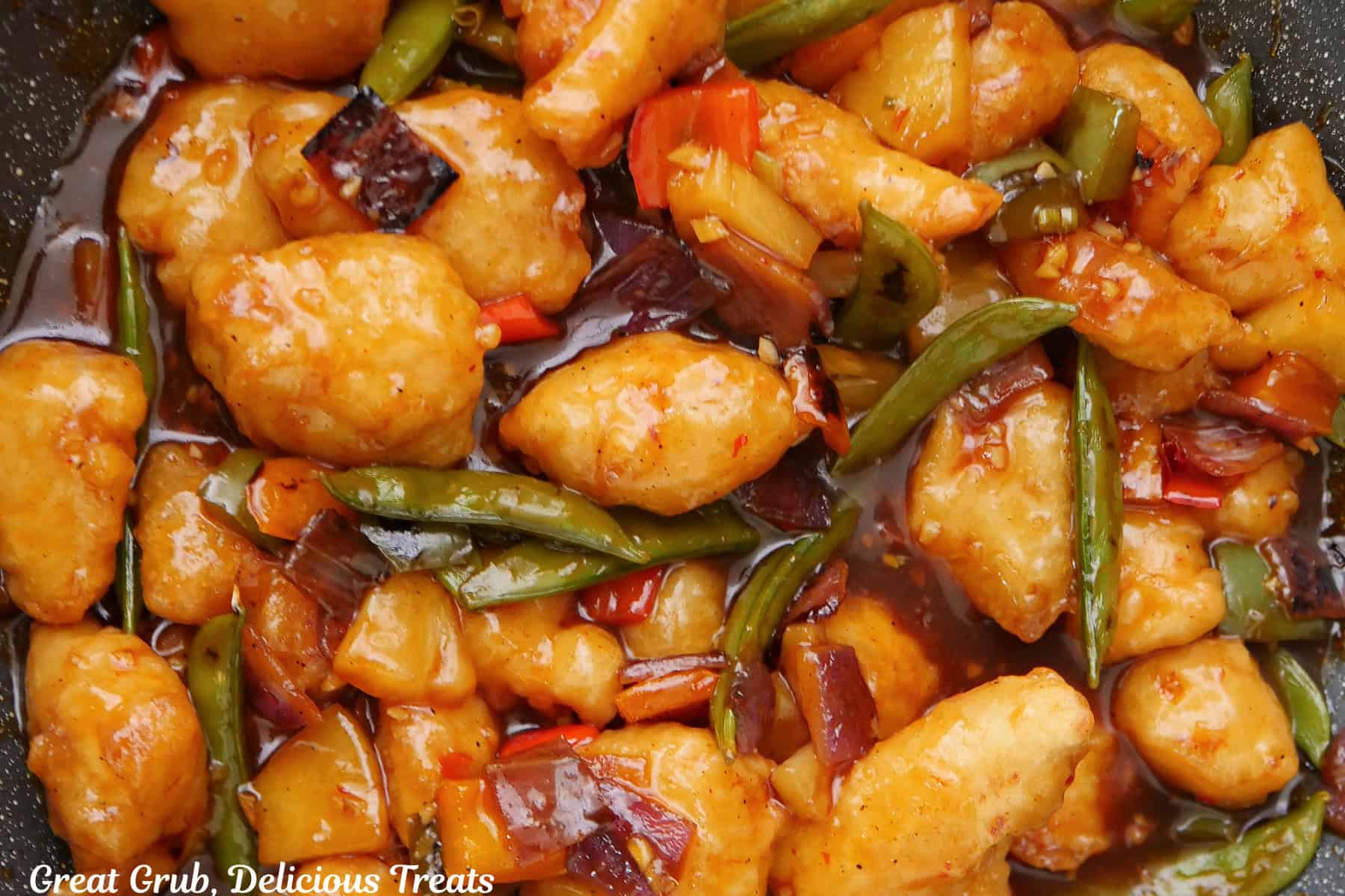 A pan with chicken stir-fry in it after being mixed together with all the ingredients.