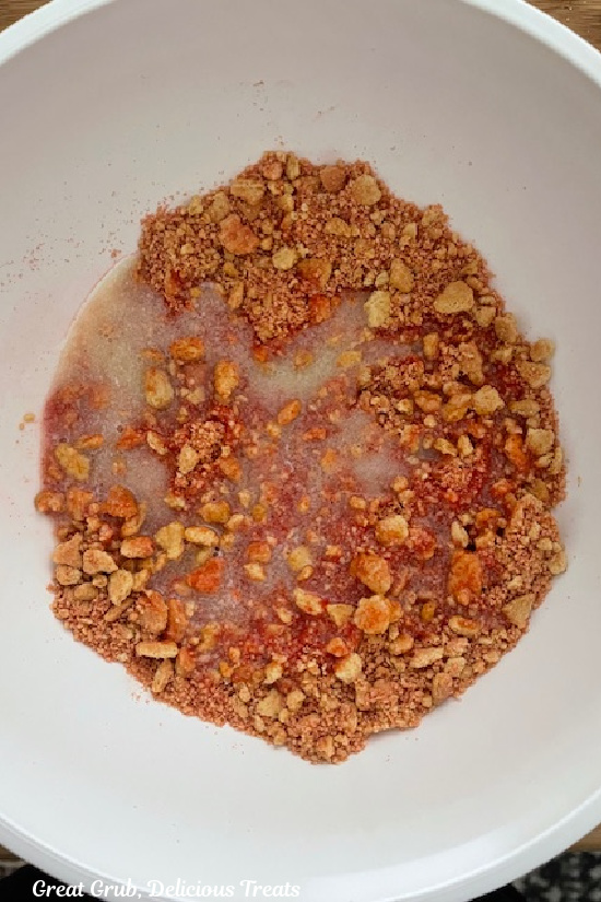 A white bowl with the strawberry crunch ingredients in it before being mixed togehter.