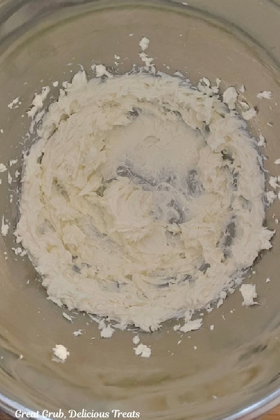 A mixing bowl with cream cheese mixture in it.