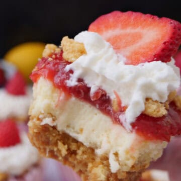 A mini strawberry lemon crunch cheesecake held up with a bite taken out of it, and a title overlay at the top.