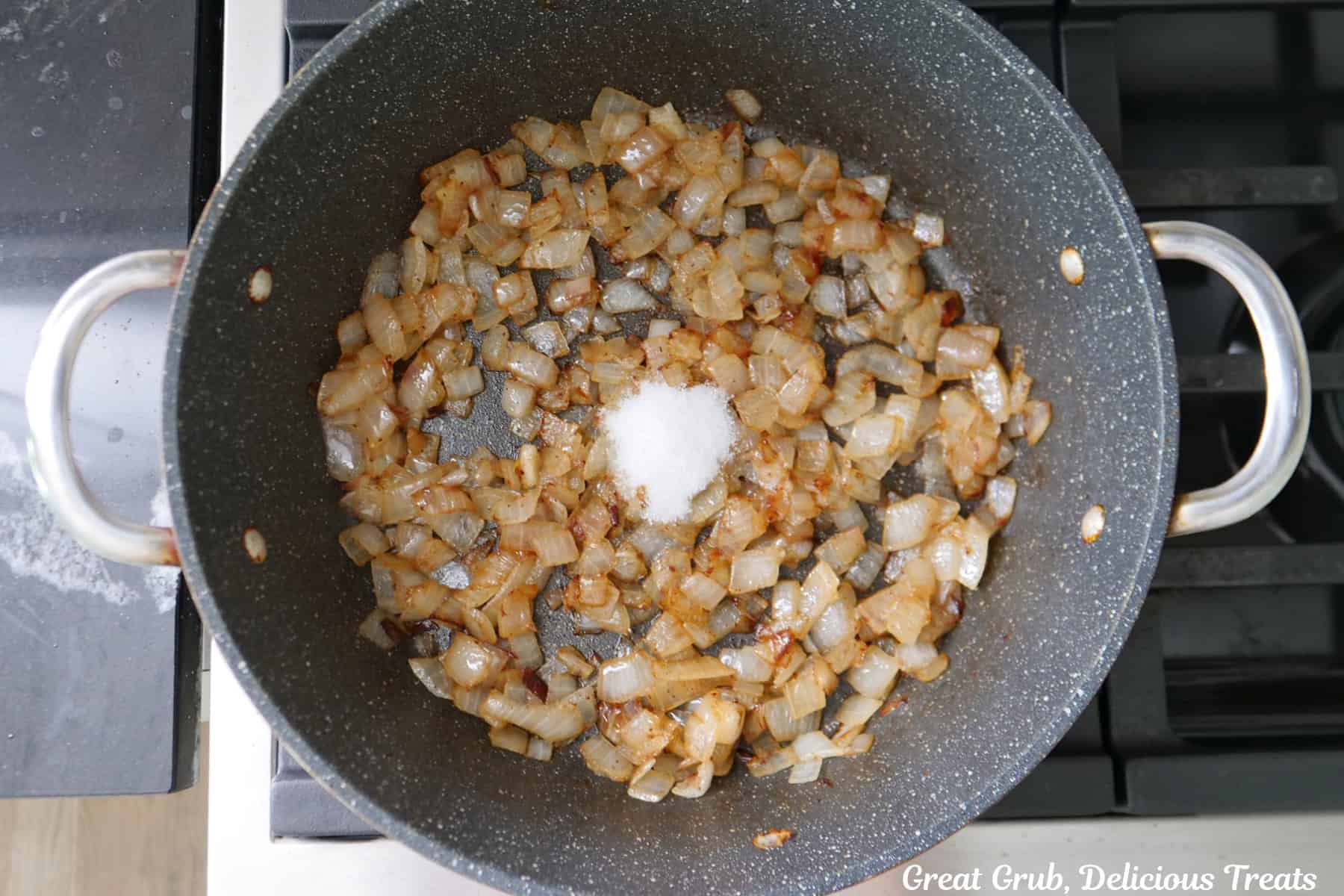 Caramelized onions in a frying pan with sugar added.
