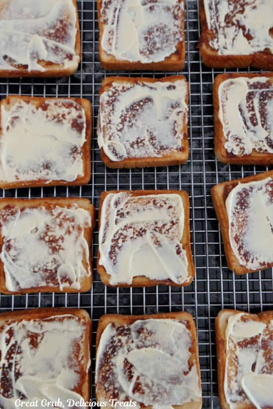 A wire rack with the grilled Texas toast with a mayo and Dijon mixture on them.