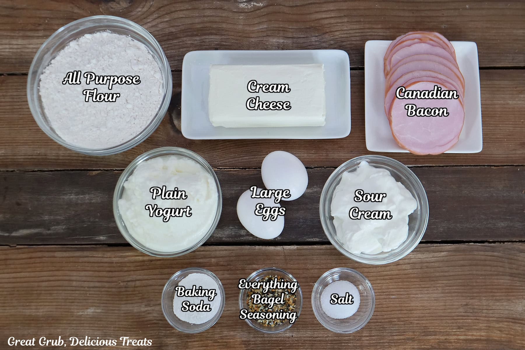 A wood surface with all the ingredients placed on it to make Everything Bagel Bombs.
