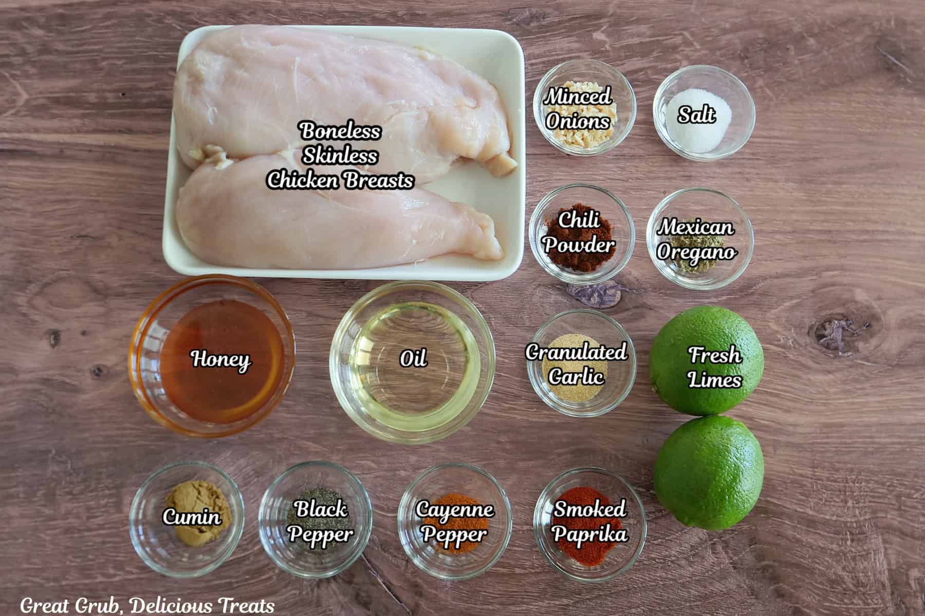 A wood surface with all the ingredients placed on it to make honey lime grilled chicken.