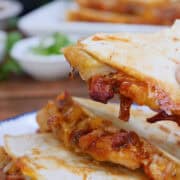 A white plate with a stack of three slices of pulled pork quesadillas on it, with a title overlay at the top.
