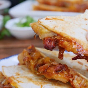 A white plate with a stack of three slices of pulled pork quesadillas on it, with a title overlay at the top.