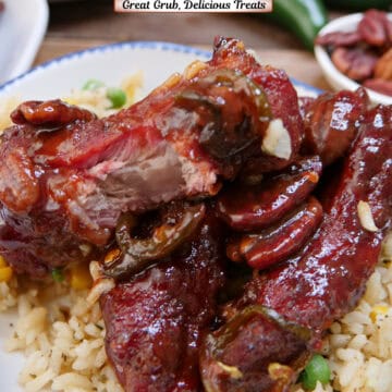 A white plate with blue trim with three maple pecan smoked ribs on a bed of vegetable rice, and a title overlay at the top.