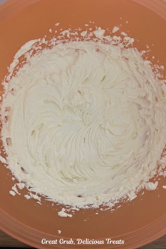 A mixing bowl with cream cheese that has been mixed until smooth.