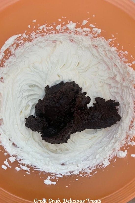 A mixing bowl with a thick chocolate pudding mix added to a smooth cream cheese mixture.