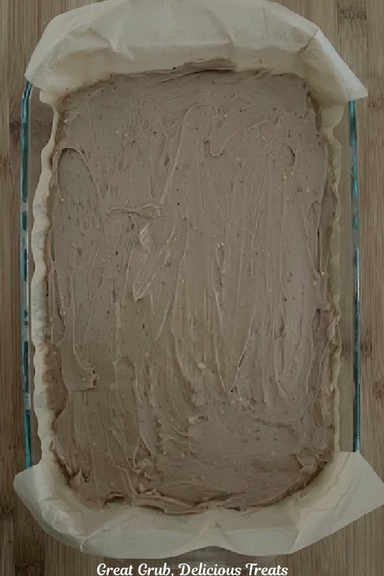 A 7 by 11 baking dish with a no-bake milky way pudding mixture spread over an Oreo crust.