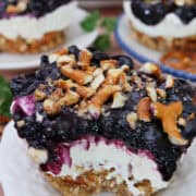 A small round plate with a jumbo mini blueberry pretzel dessert on it with a bite taken out of it, and a title overlay at the top.