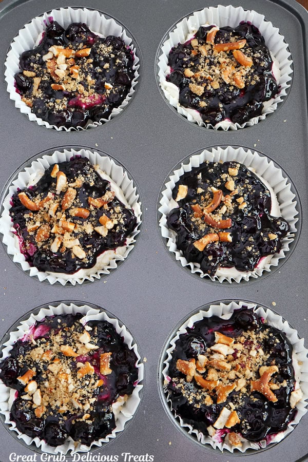 A jumbo muffin tin with the reserve pretzel crust sprinkled on top of the blueberry filling.