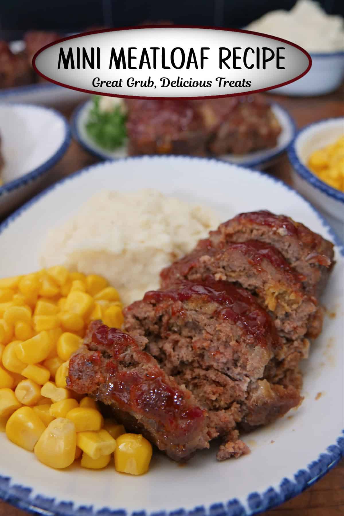 A white plate with blue trim with a sliced mini meatloaf, mashed potatoes, and corn on the plate.