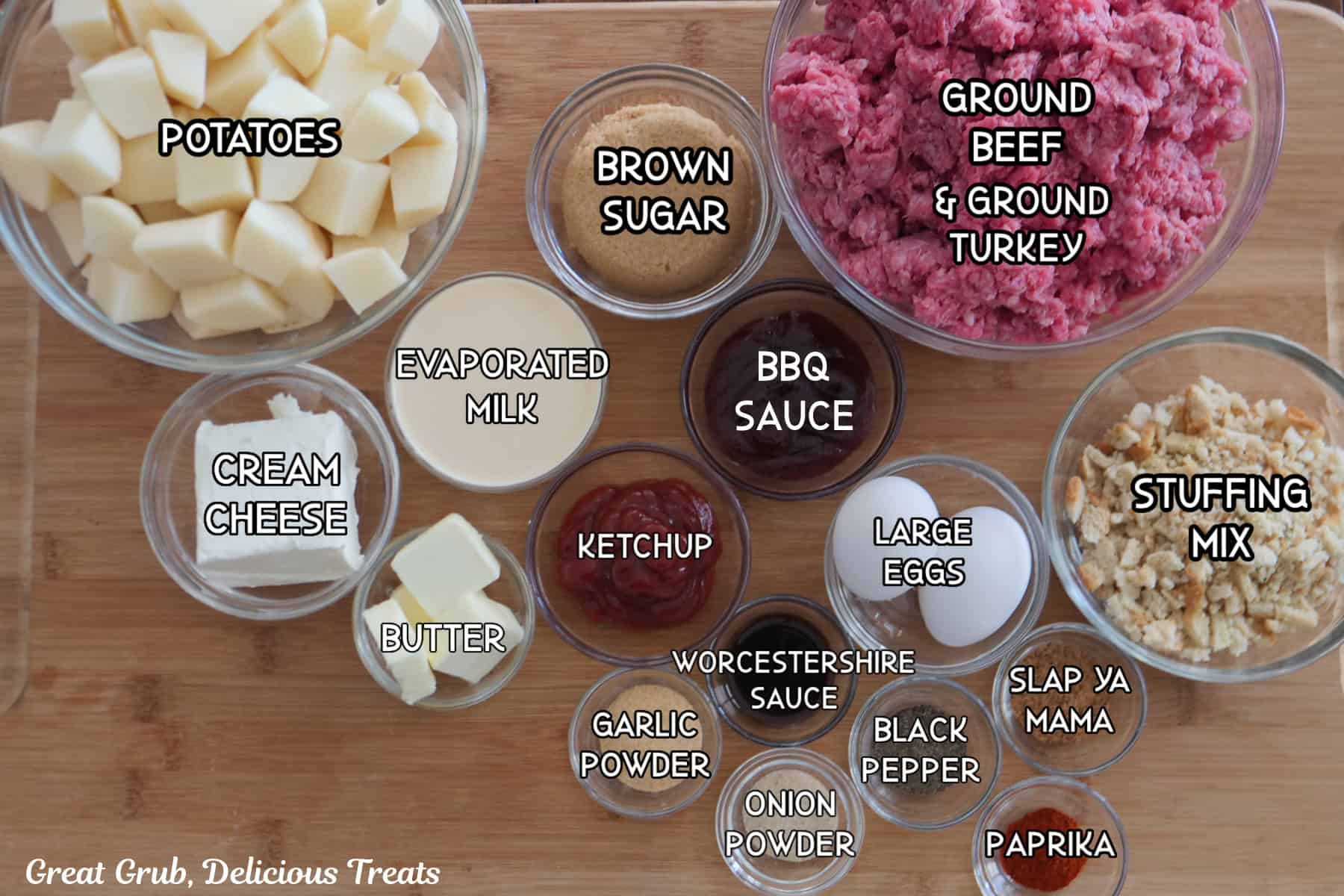 A wood surface with all the ingredients placed on it to make mini meatloaves and mashed potatoes.