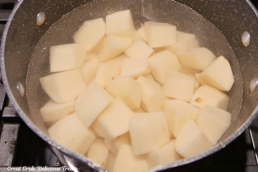 A saucepan with cubed potatoes and water covering the potatoes before being cooked.