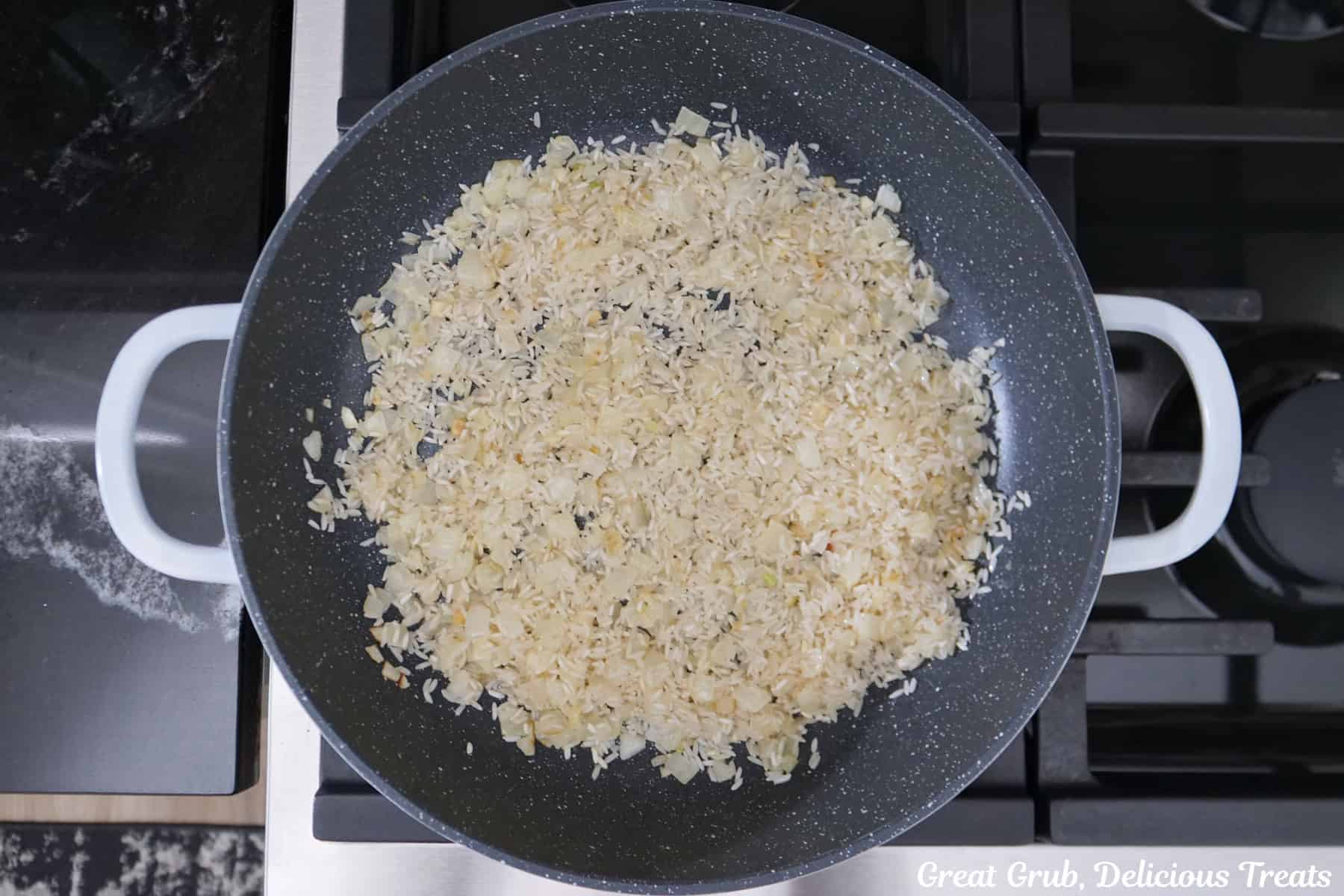 A pan with sauteed onions and garlic in it.