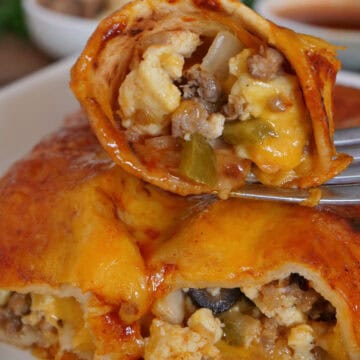 A white plate with two breakfast enchiladas on it and a bite on enchilada on a fork, with a title overlay at the top.