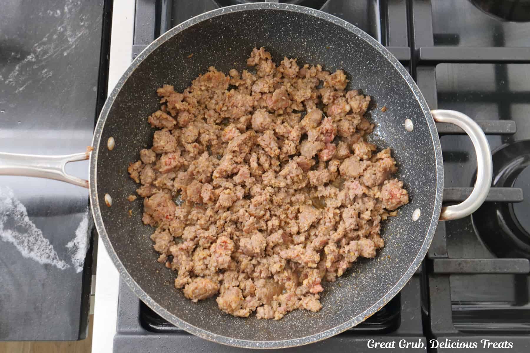 A frying pan with cooked breakfast sausage in it.